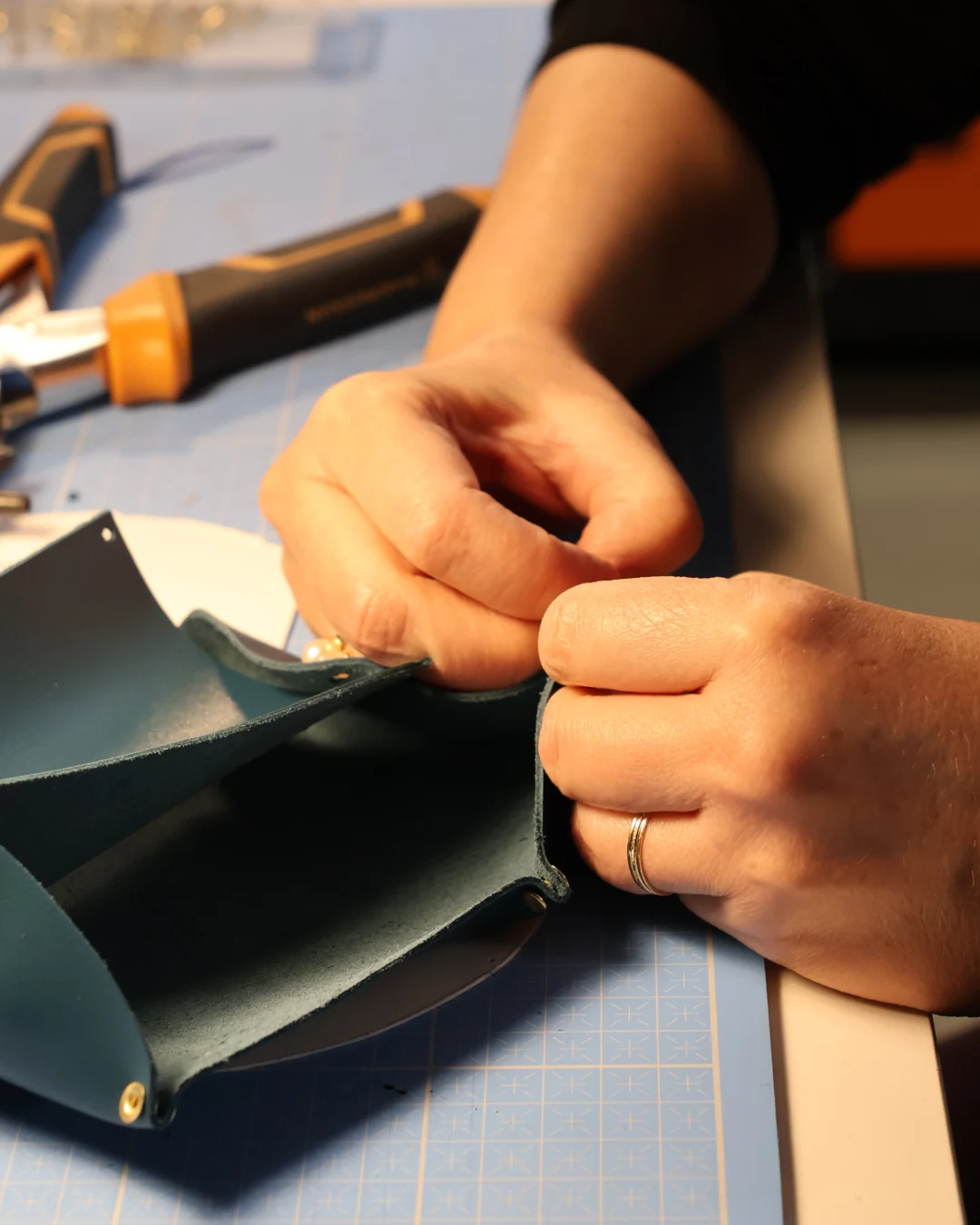 Travail du cuir et découpe manuelle lors d'un stage en maroquinerie.