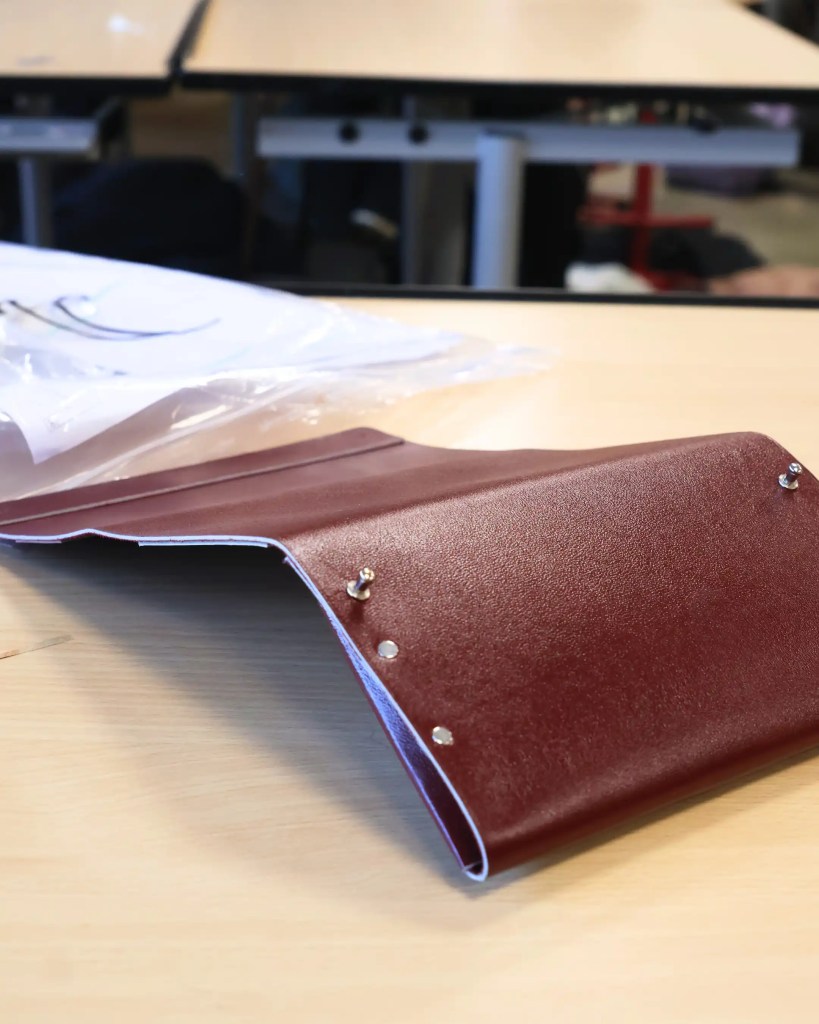 Gros plan sur une superbe trousse en cuir fabriquée à la main par un collégien durant le programme.