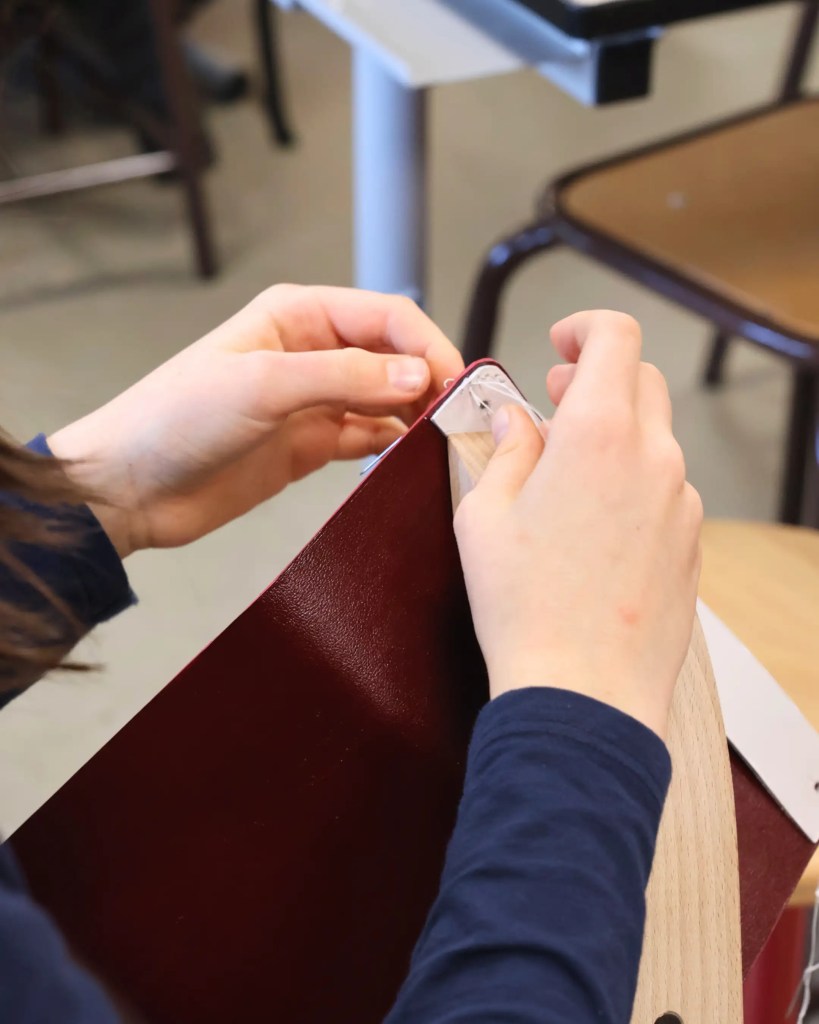 Gros plan sur une superbe trousse en cuir fabriquée à la main par un collégien durant le programme.